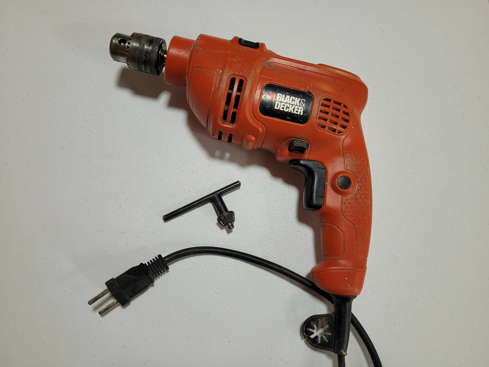 Furadeira elétrica com fio sobre uma bancada